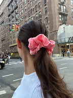Person with pink scrunchie in hair on nyc street